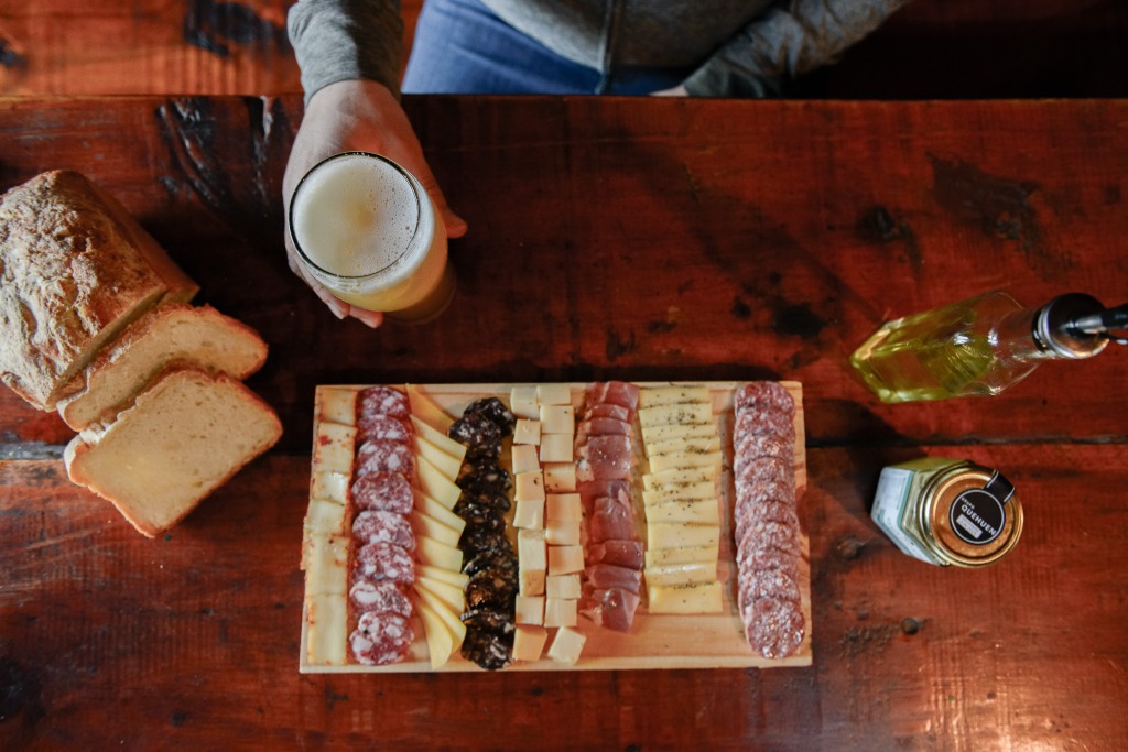 Picada con pan casero y cerveza artesanal tirada