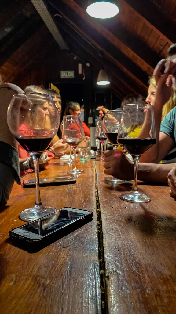 Copa de vino en la mesa común del hostel con huéspedes